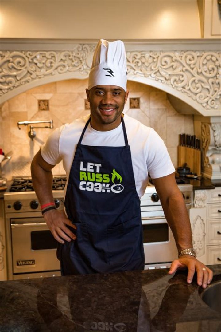 Russell Wilson Trades the Field For the Kitchen with “Let Russ Cook” Apron to Fight Hunger – Celeb Secrets